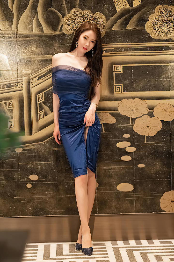 靠在墙上的蓝色抹胸长裙气质美女梦心月图片