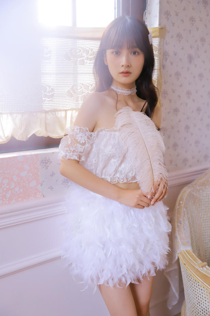 拿着羽毛的清纯白裙美女图片