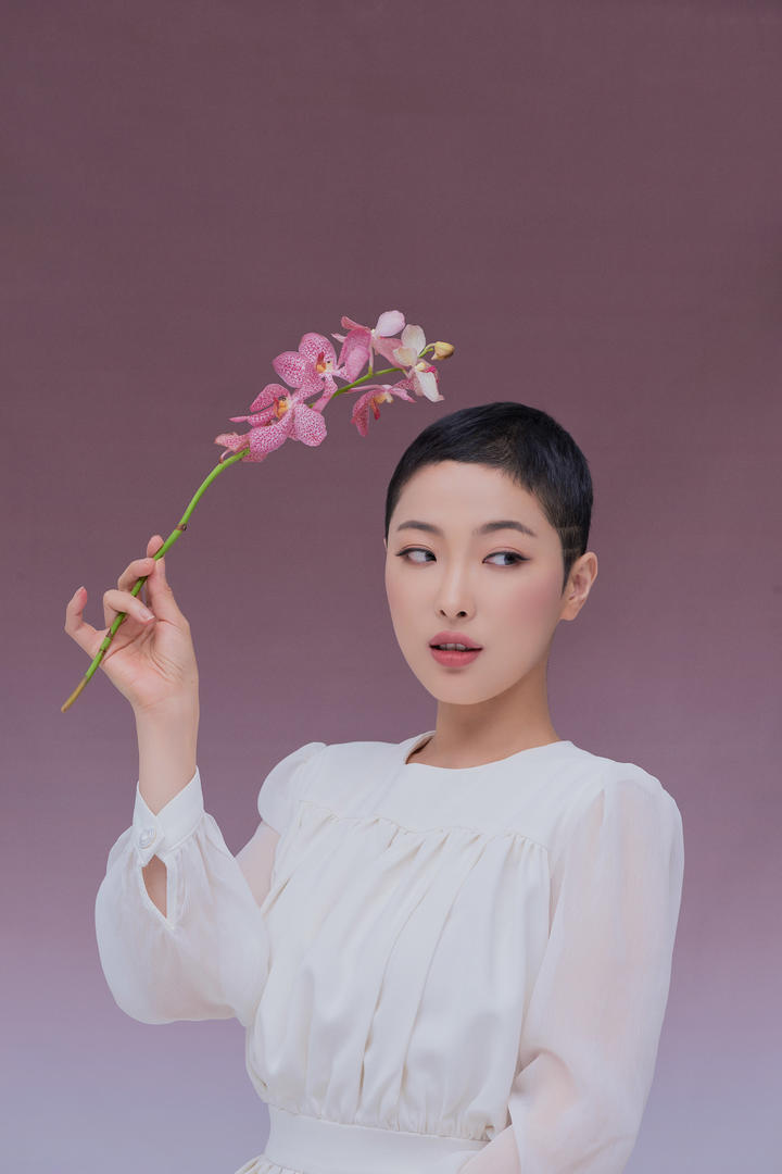 手拿一枝兰花的美女女生艺术写真摄影图片