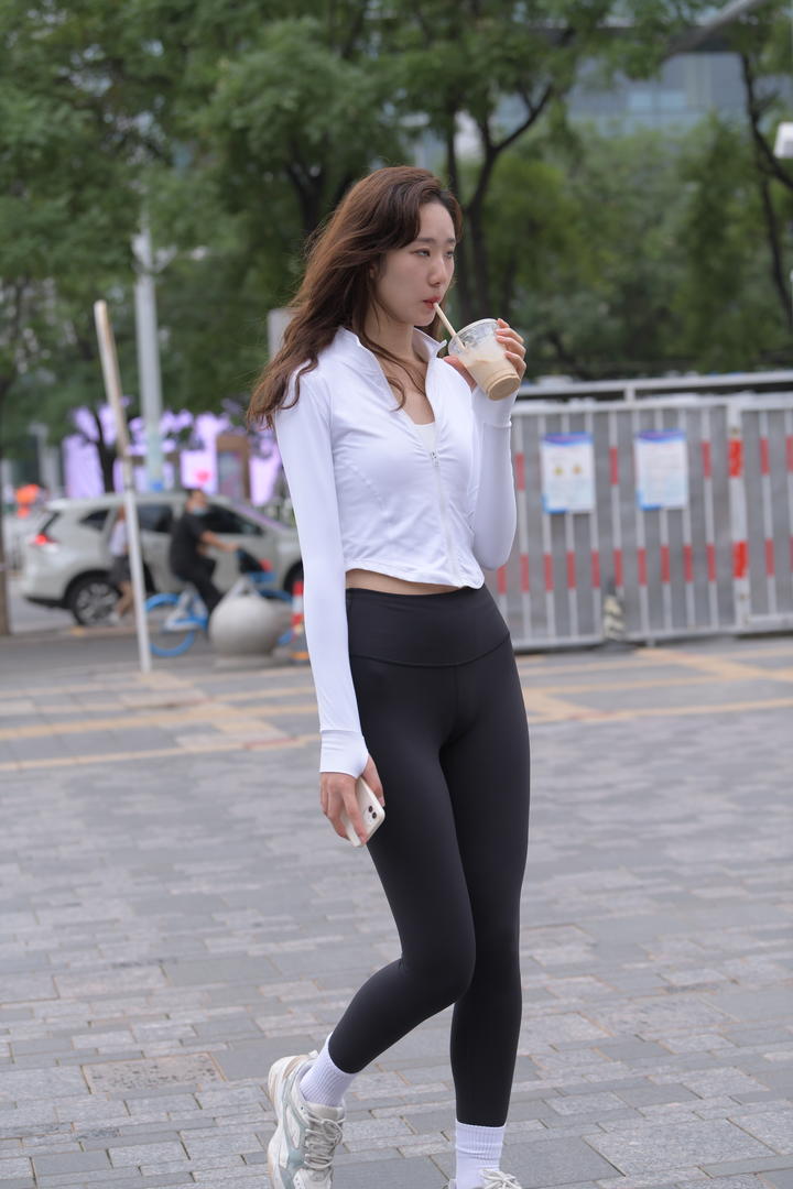 街头偷拍喝奶茶的紧身裤美女图片