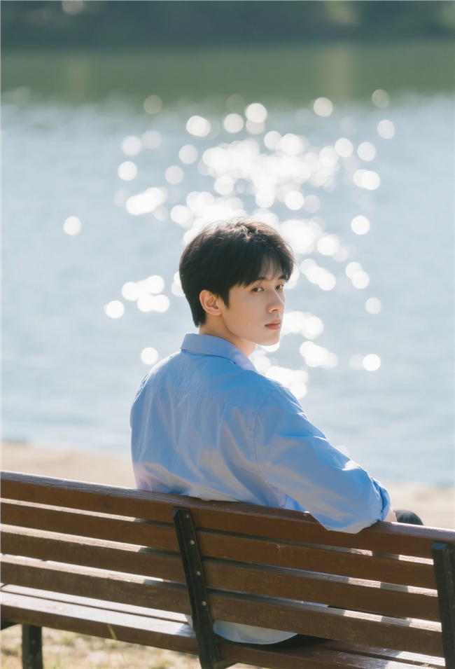 湖边坐在长椅上回眸的帅哥图片