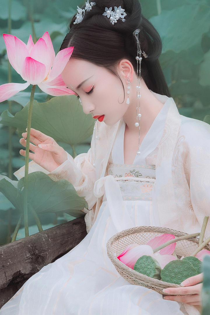 坐在船上采荷花的古典美女写真图片