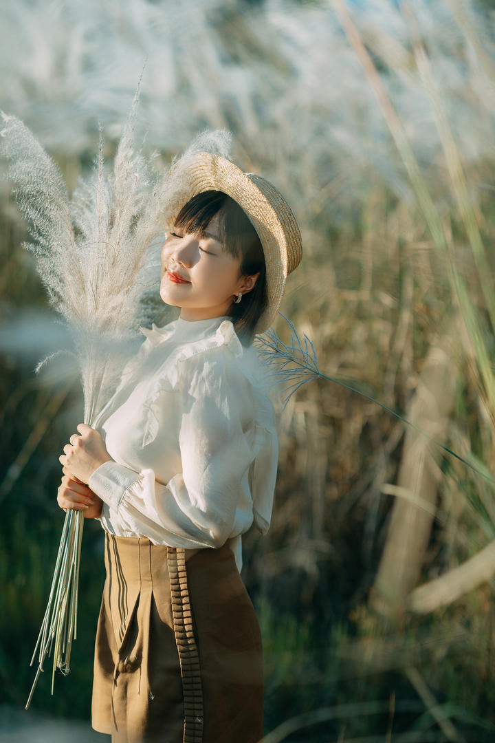 草丛里戴着草帽的清纯甜美女生户外摄影图片