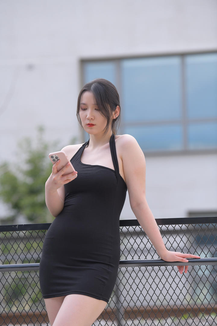 靠在栏杆上玩手机的克拉女神美女街拍套图