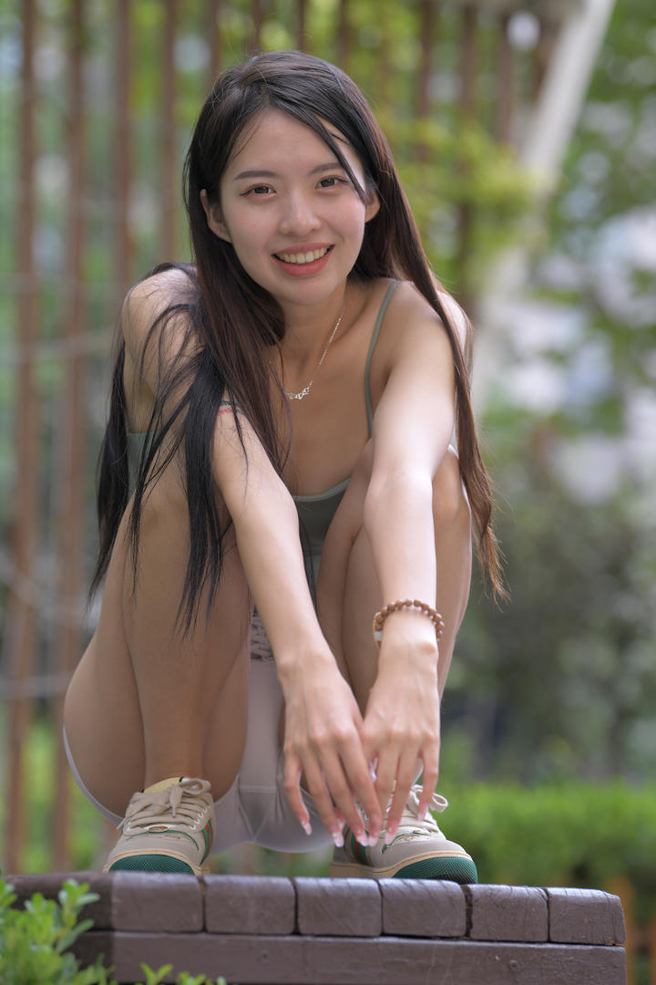 蹲在街上的紧身裤凹凸美女写真图片