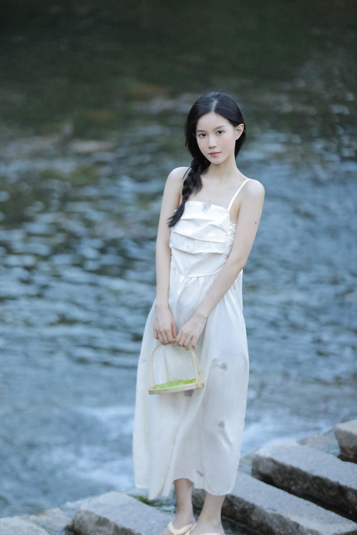 穿着吊带白裙的白月光女孩户外踏青写真图片