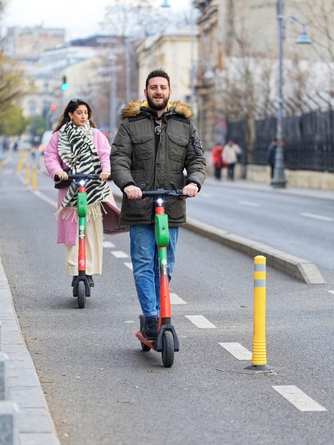 街头骑着电动滑板车的情侣图片