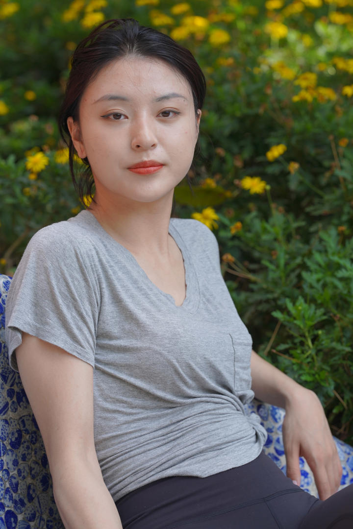 躺在花丛中的漂亮紧身裤美女户外摄影图片