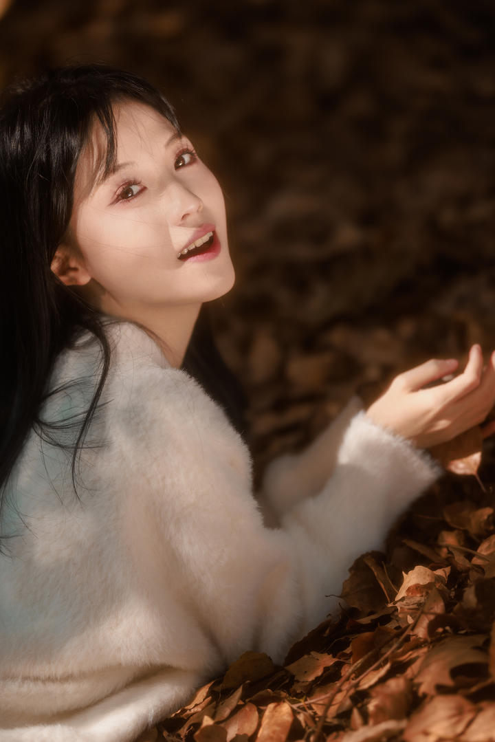 趴在落叶上的甜美养眼女孩高清人像摄影图片