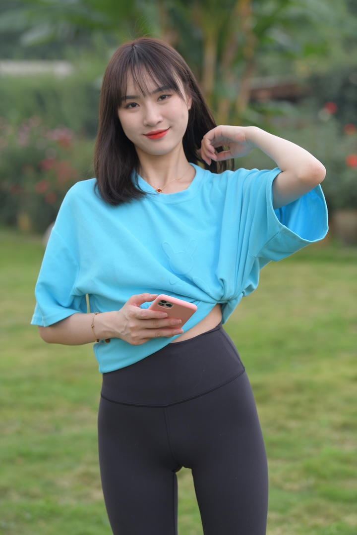 拿着手机的紧身裤美女街拍图片