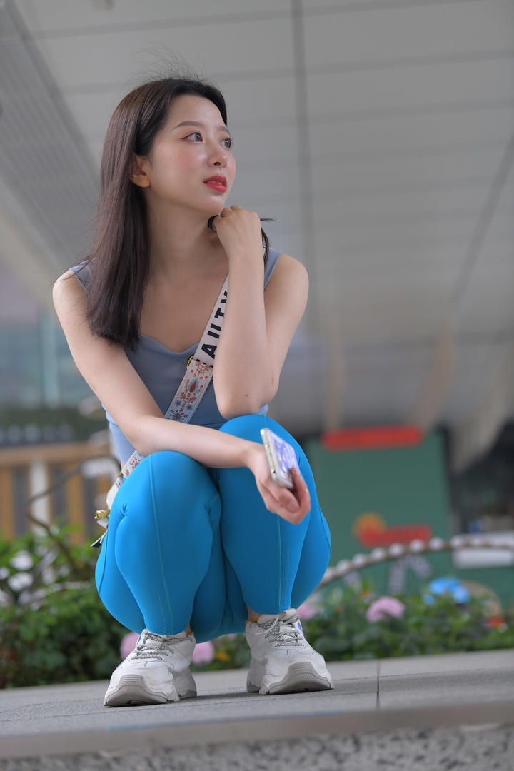 街拍蹲在地上的清纯紧身瑜伽裤美女模特高清图片