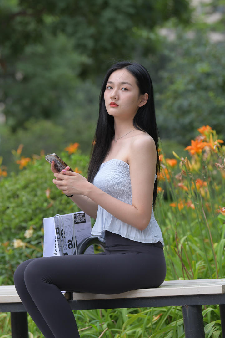 坐在长椅上休息的街拍紧身裤美女图片集