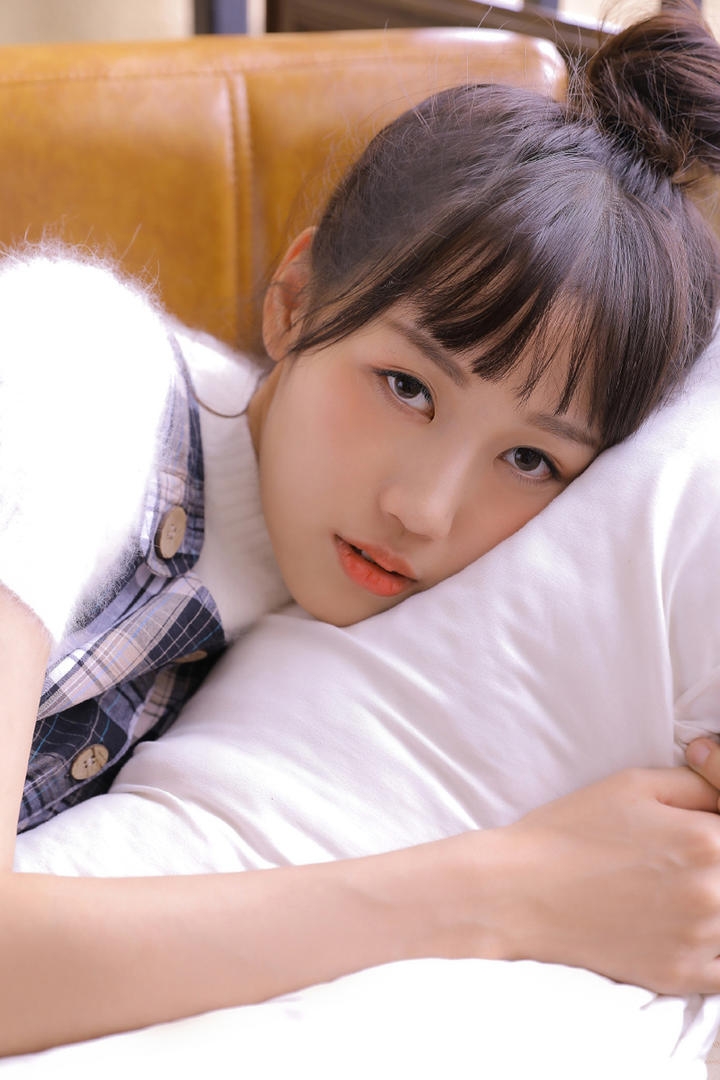 趴在床上的齐刘海发型女生图片