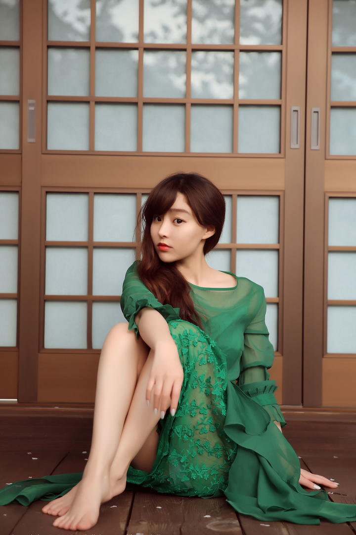 坐在地板上的绿色长裙美女图片