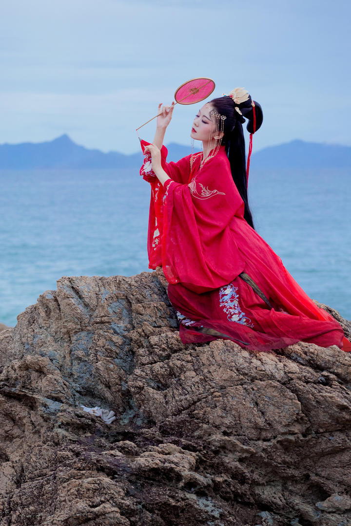 海边礁石上的唯美红色古装美女航子艺术写真图片
