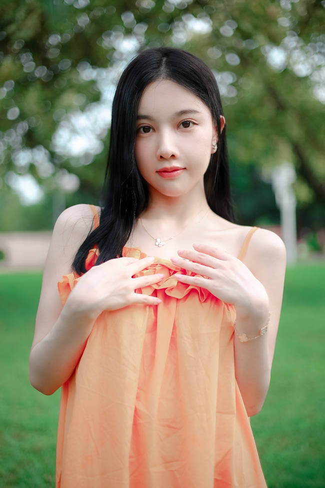 春天户外草地橙色吊带裙性感美女图片