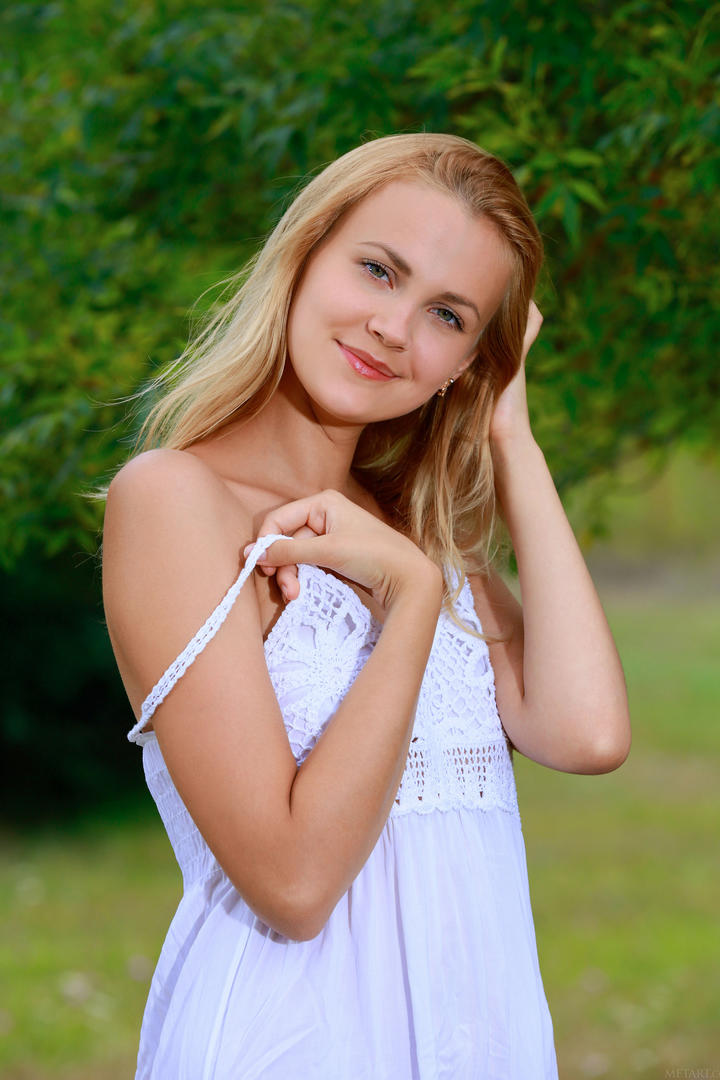 穿着白裙子的欧美金发美女户外写真图片