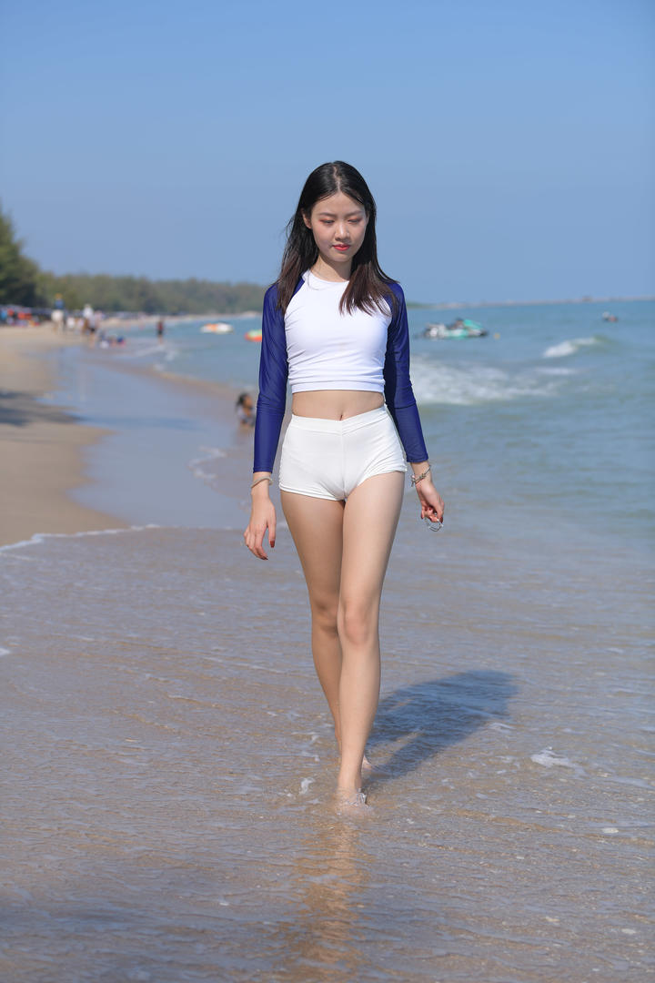 沙滩上漫步的清纯紧身裤美女写真图片