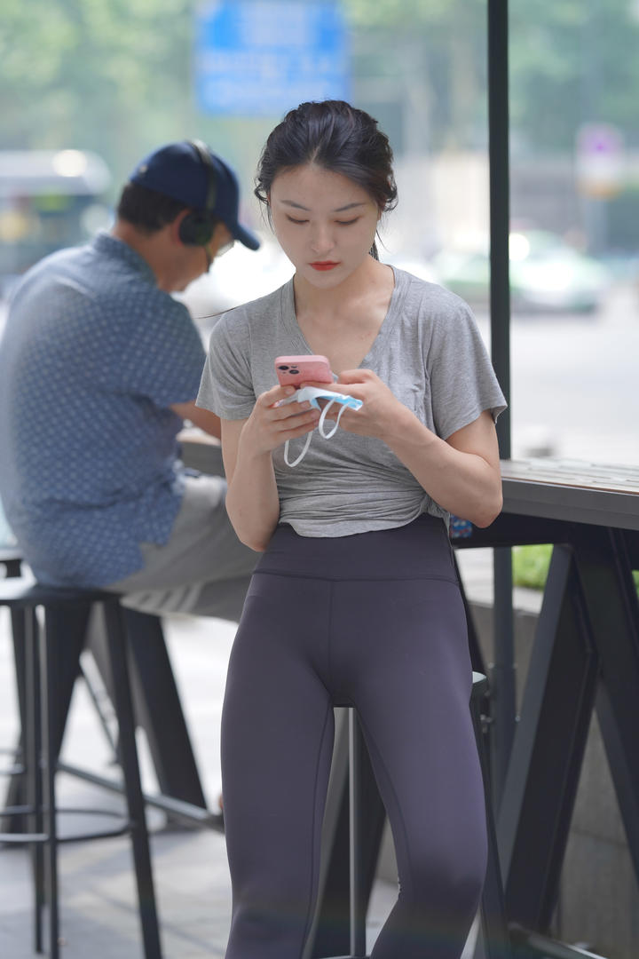 咖啡店偷拍玩手机的瑜伽裤美女高清图片