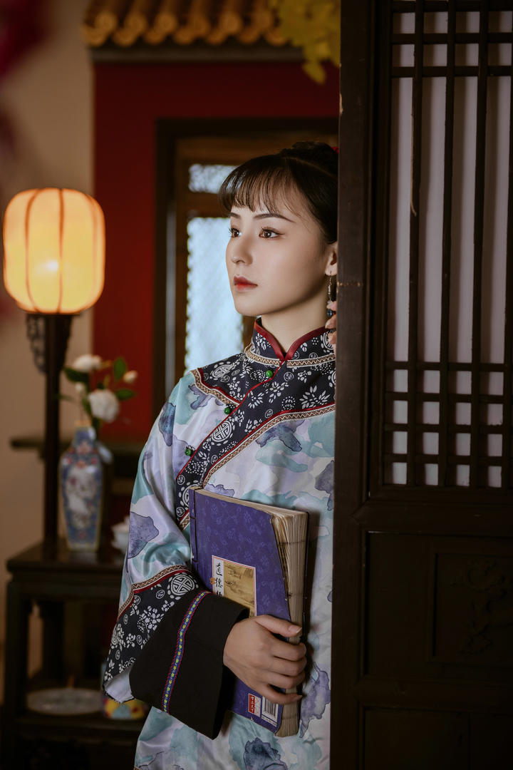 抱着古籍的旗袍美女艺术写真图片
