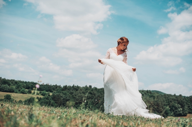 站在山坡上的白色婚纱美女图片