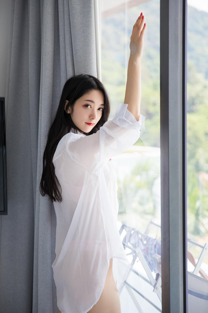 趴在窗户边的白色衬衣美女图片