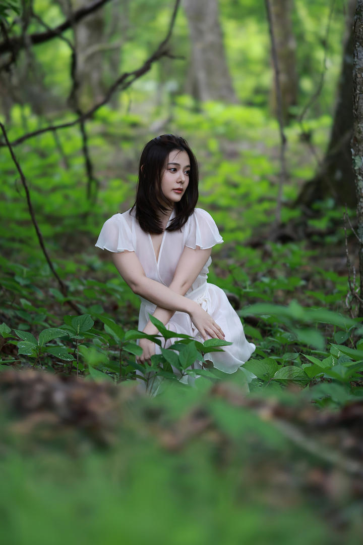 蹲在森林中的清纯美女高清图片