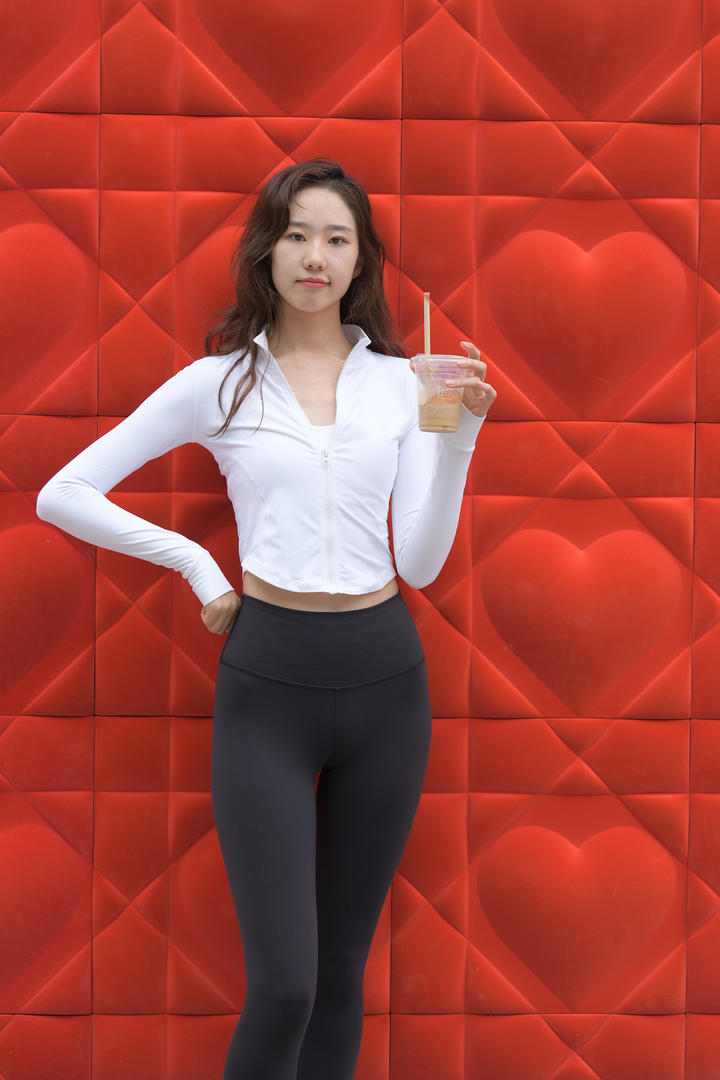 拿着奶茶的美女街拍紧身裤美女写真图片