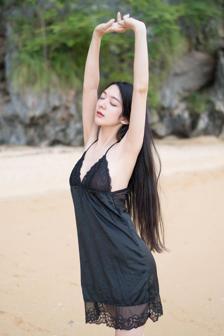 穿着黑色睡裙站在沙滩上的高清美女图片
