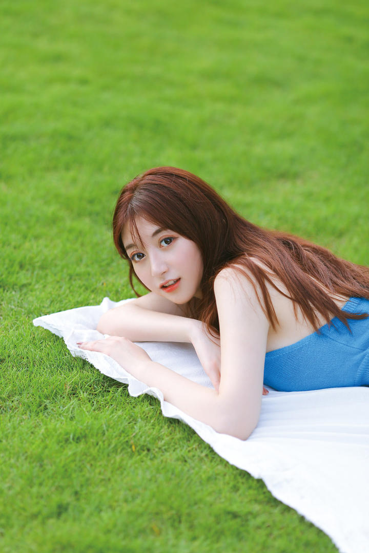 趴在草地上的清纯养眼美女写真图片