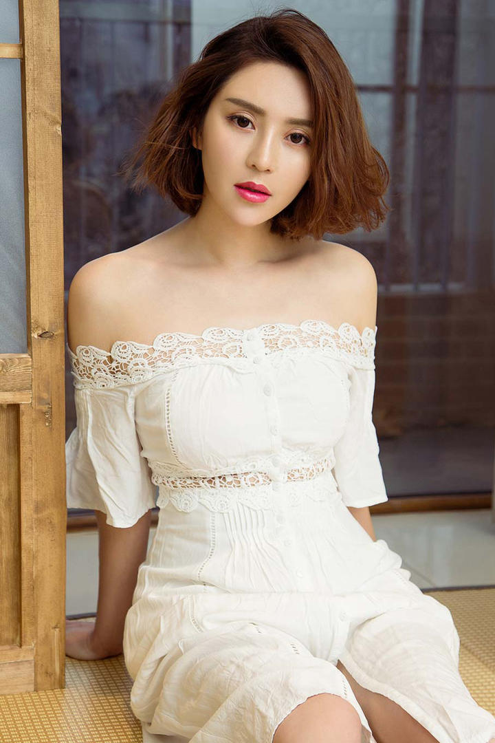 穿着白色裙子坐在地上的气质短发美女图片