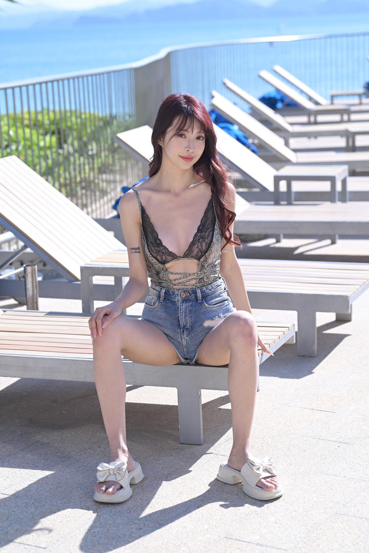 坐在沙滩椅上的漂亮美女主播性感比基尼穿搭图片