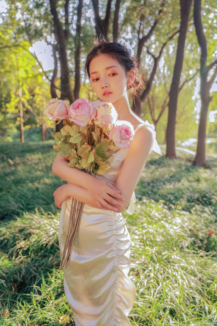 抱着花朵的清纯女生户外写真图片